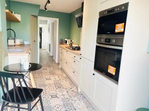 uma cozinha com uma mesa e um fogão forno superior em The Heath Retreat em Whitstable