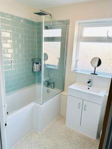 a bathroom with a shower and a tub and a sink at The Heath Retreat in Whitstable