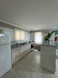 een keuken met witte kasten en een witte koelkast bij Dpto, 4 Estaciones I in El Bolsón