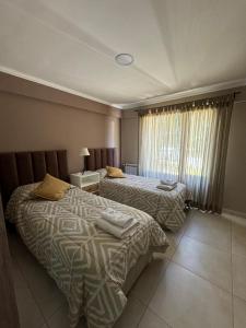 een hotelkamer met twee bedden en een raam bij Dpto, 4 Estaciones I in El Bolsón