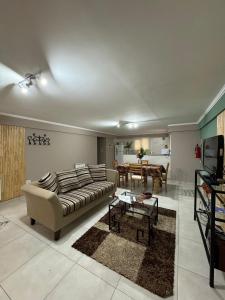 een woonkamer met een bank en een tafel bij Dpto, 4 Estaciones I in El Bolsón