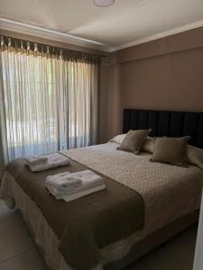 een slaapkamer met een groot bed met handdoeken erop bij Dpto, 4 Estaciones I in El Bolsón