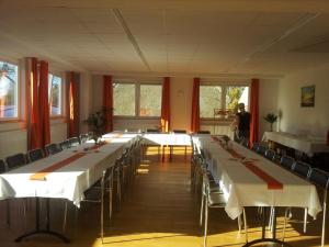 a large room with long tables and chairs and a woman at Sefano Nossen in Nossen