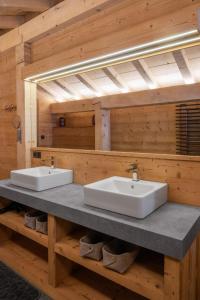a bathroom with two sinks on a wooden wall at Chalet du Paradis Blanc in La Bresse +22 photos