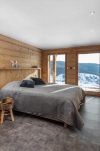 a bedroom with a large bed and a large window at Chalet du Paradis Blanc in La Bresse