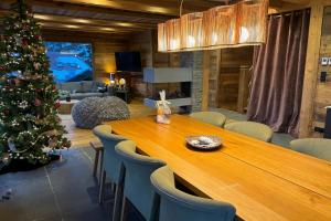 a christmas tree in a living room with a table and chairs at Chalet du Paradis Blanc in La Bresse