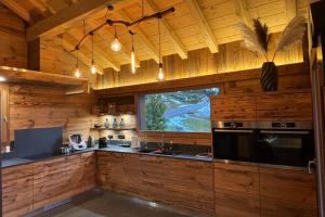 a kitchen with wooden walls and a large window at Chalet du Paradis Blanc in La Bresse