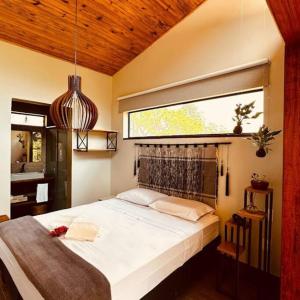 Cabanas da Mata - Cabana Candeia - Casa Branca/MG في كازا برانكا: غرفة نوم بها سرير أبيض كبير مع نافذة