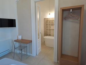 Cette chambre comprend une salle de bains pourvue d'une table et d'une baignoire. dans l'établissement Palazzo AD 1892 - SUITES & SPA, à Ostuni