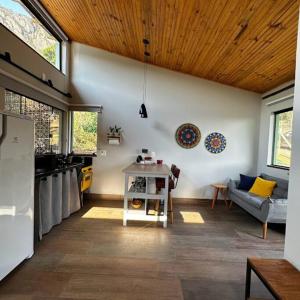 Cabanas da Mata - Cabana Candeia - Casa Branca/MG في كازا برانكا: مطبخ وغرفة معيشة مع أريكة وطاولة