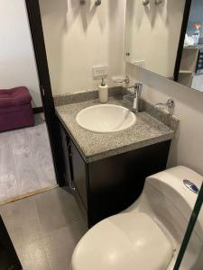 a bathroom with a white sink and a toilet at Lovely 1-bedroom apartment at Chapinero's heart in Bogotá