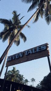 a sign with a palm tree in the background at Seven Tales in Anjuna
