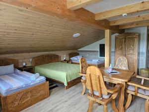 1 dormitorio con 1 cama, mesa y sillas en Bakony Kőhegy vendégház, en Csehbánya