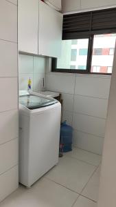 uma pequena cozinha branca com um lavatório e uma janela em Apartamento de Alto Padrão Próximo à UFPE & Hospital Das Clínicas em Recife