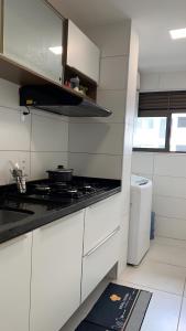 uma cozinha com armários brancos e um forno com placa de fogão em Apartamento de Alto Padrão Próximo à UFPE & Hospital Das Clínicas em Recife