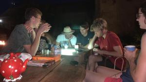 grupa młodych mężczyzn siedzących przy drewnianym stole w obiekcie YXIE - Manoir des Arts w mieście Villeblevin