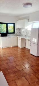 an empty kitchen with white cabinets and a wooden floor at Noclegi u Ewusi in Januszowice