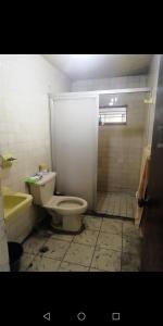a dirty bathroom with a toilet and a shower at Habitación en Casa Compartida in Monterrey