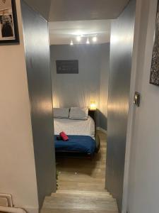ein kleines Schlafzimmer mit einem Bett auf dem Flur in der Unterkunft F1 Meublé et Confortable en cœur de ville in Longjumeau