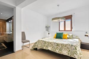 a bedroom with a bed and a chair at Somni in Jávea