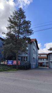 a tree in front of a building with a street at Henrix in Warsaw