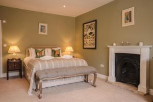 a bedroom with a bed and a fireplace at The Loddon Swan in Loddon