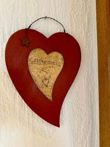 un signo en forma de corazón colgando de una pared en Apartment Happy, en Homburg