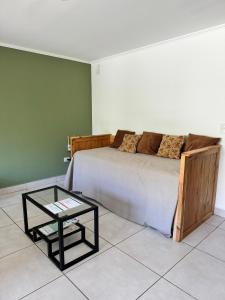 1 dormitorio con cama y mesa de cristal en Dpto, 4 Estaciones II en El Bolsón