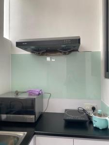 eine Mikrowelle auf einer Theke in einer Küche in der Unterkunft Homely house in Kuching