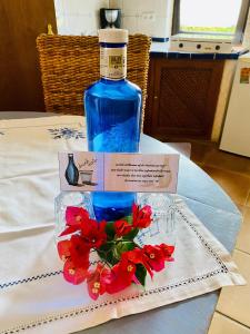 a bottle of water and red flowers on a table at FincaOase-Can-Negre-Son-Macia-App-Petit in Son Macia