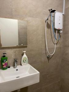 W łazience znajduje się umywalka i prysznic. w obiekcie Homely house w mieście Kuching