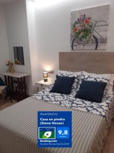 a bedroom with a bed with a blue sign on it at Casa en piedra (Stone House) in Porriño