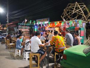 a group of people sitting at tables in a market at Peekaboo house in Ubon Ratchathani