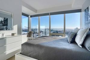 um quarto com uma cama grande e uma janela grande em Spectacular Skyline Views - Downtown Montreal - Luxury Condo & Penthouse em Montréal