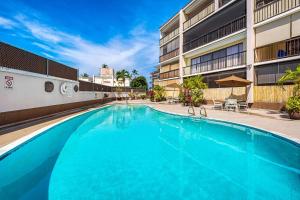 Una gran piscina azul frente a un edificio en Kona Plaza#218, en Kailua-Kona