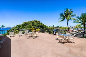 un patio con sillas, mesas, mesa y sillas en Kona Plaza#218, en Kailua-Kona