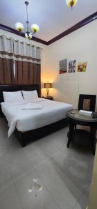 1 dormitorio con 1 cama grande y 1 mesa en Al Smou Hotel Apartments - MAHA HOSPITALITY GROUP, en Ajman