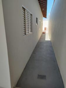 un corridoio vuoto di un edificio bianco con finestra di Casa de Temporada Isaura a Olímpia