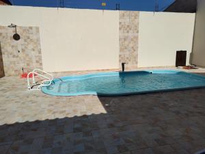 a swimming pool in a room with a tile floor at Casa de Temporada Isaura in Olímpia