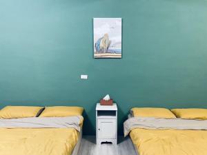 2 camas en una habitación con paredes azules en 綠色的日子, en Nantou City