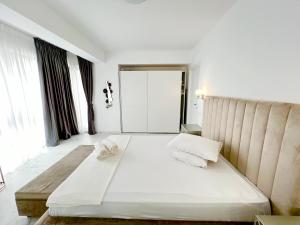 a bedroom with a large white bed with two pillows at LUXURY Residence 2 bed-room Apartment in Mamaia