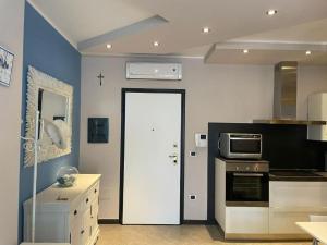 een keuken met een witte deur en een magnetron bij Civico 8 Alexander in Alghero