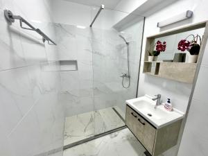 a white bathroom with a shower and a sink at LUXURY Residence 2 bed-room Apartment in Mamaia +52 photos