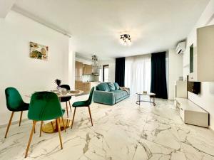 a living room with a table and green chairs at LUXURY Residence 2 bed-room Apartment in Mamaia