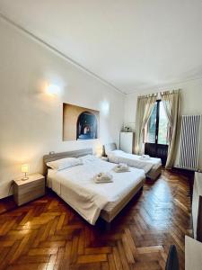 フェラーラにあるCentro Storico Suitesのウッドフロアのベッドルーム(ベッド2台付)