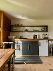 a kitchen with a white refrigerator and a wooden table at PLŪSME Restart House in Lielstraupe
