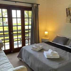 1 dormitorio con 1 cama con 2 toallas en Aparts Laguna Camp en Chascomús