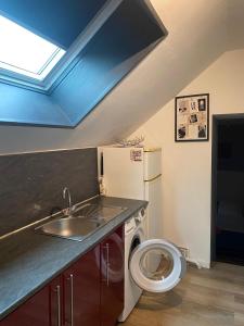 a kitchen with a sink and a washing machine at F1 Meublé et Confortable en cœur de ville in Longjumeau
