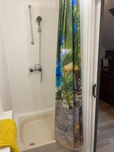 a shower curtain with a palm tree on it at F1 Meublé et Confortable en cœur de ville in Longjumeau