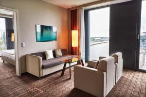 a living room with a couch and chairs in a hotel room at Steigenberger Hotel Bremen in Bremen